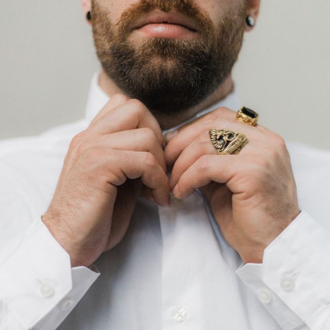 Man buttoning a white dress shirt